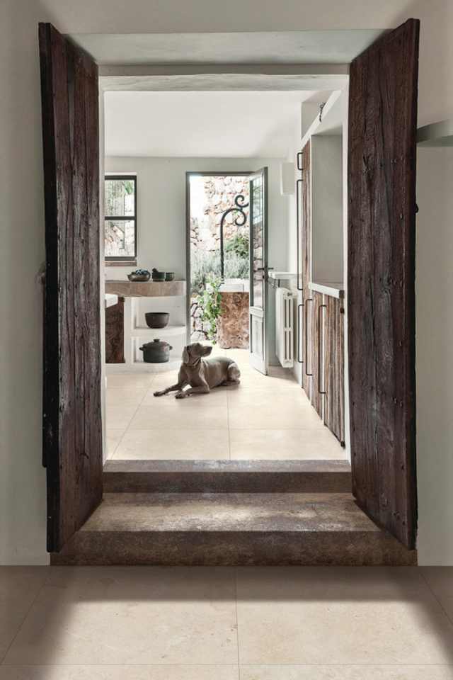 ivory colored limestone tile in southwest style entryway with wood doors